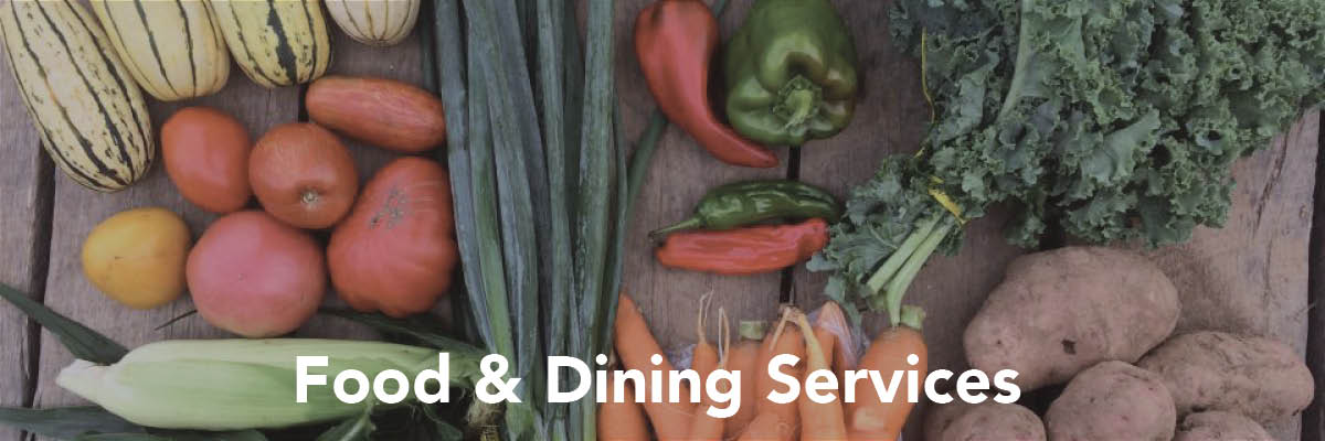 A collection of fresh produce layed across a table. At the bottom of the image is text that reads "Food and dining services"