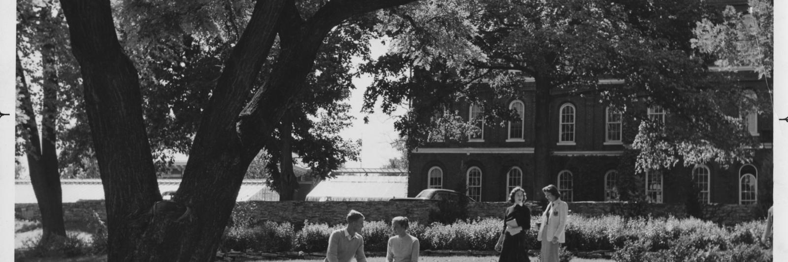 4 students socializing in botanical garden.