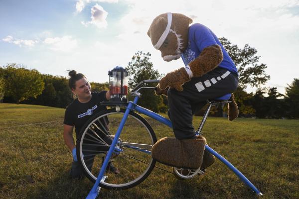 Wildcat mascot rides smoothie bike at festival