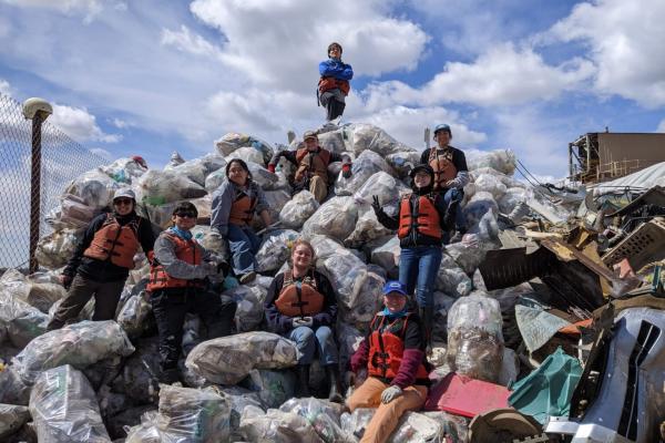 Students standing on top of trashbags 