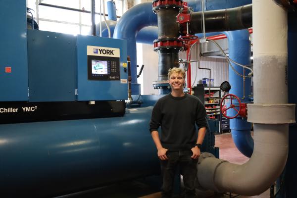 Student stands in front of chiller 