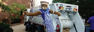 The University of Kentucky mascot hanging off the back of a garbage truck