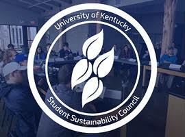 A white circle on a blue tinted background of a classroom with four leaves inside. Around the edge the words "University of Kentucky and Student Sustainability Council" are visible