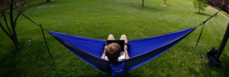 A person sitting on a blue hammock