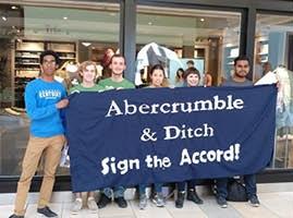 A collection of students outside of a retail store, holding a sign that reads "Abercrumble and ditch, sign the accord"