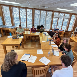 SSC students gather around a table to discuss a proposal at the annual Fall Retreat.