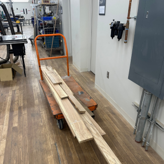 Planks of cut wood on an orange cart in Gray Design Building
