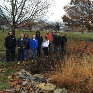 A collection of students standing in front of a field.