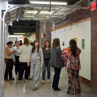 Students browse the tree-themed Resiliently Rooted gallery at SAVS