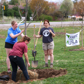 Students planting tree at plant for planet event 