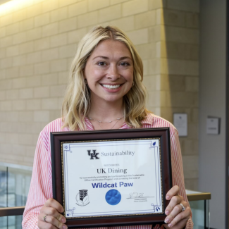 Erin Hafner from UK Dining holding a Wildcat Paw SOCP certification