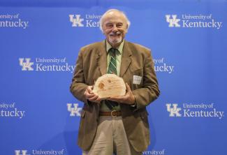 Ernie Yanarella posing with award