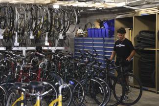 student with rack of bikes at wildcat wheels bicycle library