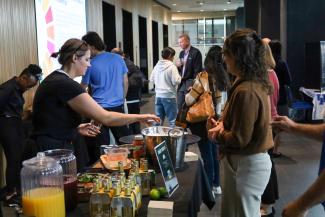Event attendees wait in line for catered food from a bar