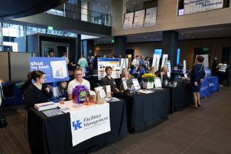 Exhibitors sit at tables at the annual sustainability showcase