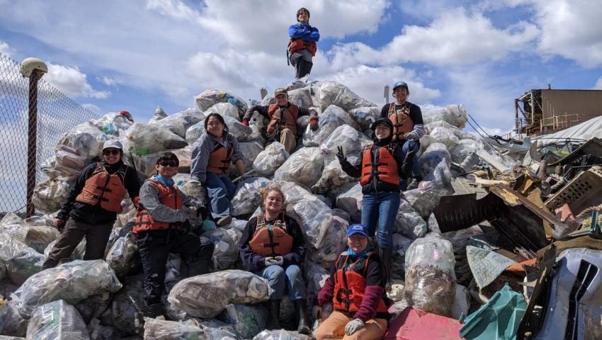 Students standing on top of trashbags 